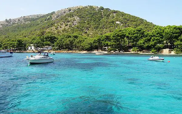 boats in turquoise water and Tramuntana mountains in Puerto Pollensa